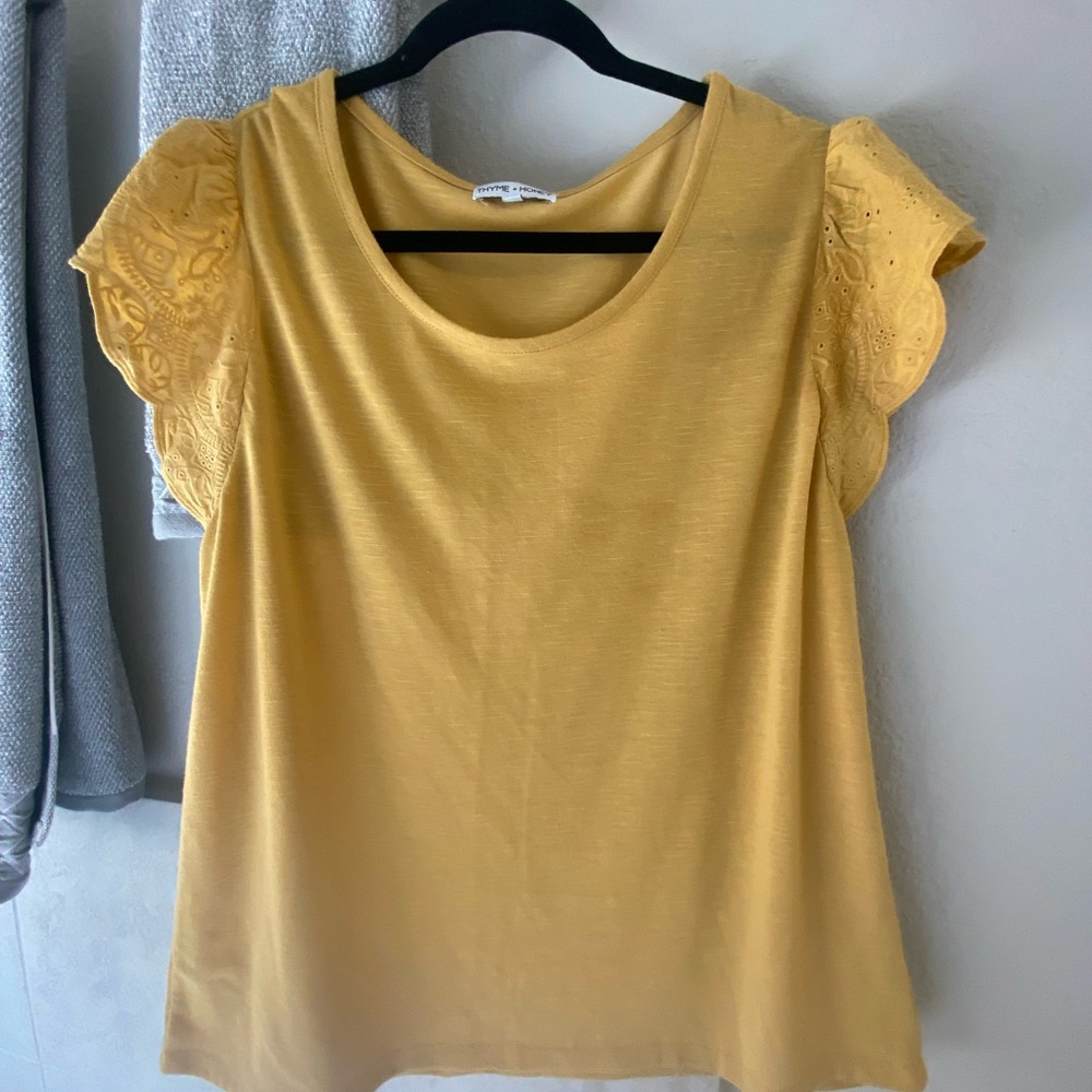 Simple mustard color shirt with ruffled sleeves.